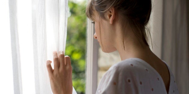 a woman is looking out of a window