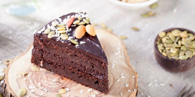 Vegan chocolate beet cake with avocado frosting, decorated with nuts and seeds