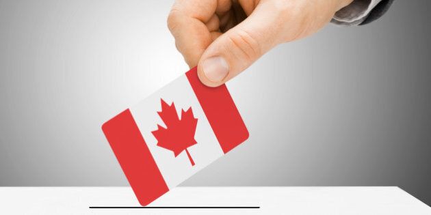 Voting concept - Male inserting flag into ballot box - Canada