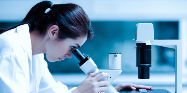 scientist using a microscope in ...