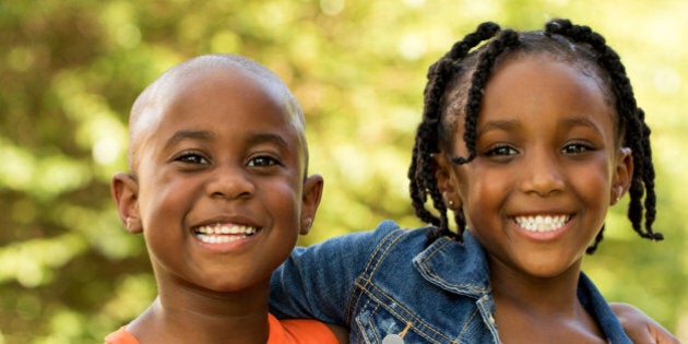 Brother and sister looking at the camera smiling.