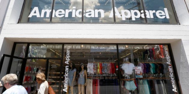 FILE - In this Wednesday, July 9, 2014, file photo, passers-by walk in front of the American Apparel store in the Shadyside neighborhood of Pittsburgh. American Apparel said Monday, Oct. 5, 2015, it is filing for Chapter 11 bankruptcy protection. The company said that its U.S. retail stores will continue to operate and that its international stores are not affected. (AP Photo/Keith Srakocic, File)