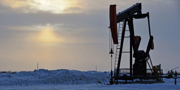 An oil well pump jack in a snow covered winter landscape.