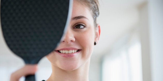 Hispanic girl admiring herself in mirror