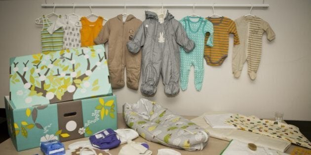 This photo taken on Aug. 15, 2012 shows the contents of the Finnish baby box, in Helsinki, Finland. Finland's social security service has given a baby box to Prince William and former Catherine Middleton, who are expecting their first baby in mid-July. The brightly colored cardboard box doubles as a cot, complete with mattress and sheets, and contains numerous baby items including a sleeping bag, jump suits, socks, pants, hats, bonnets and diapers. Maternity packages have been given to expectant mothers in Finland since 1938. (AP Photo/Lehtikuva, Roni Rekomaa) FINLAND OUT