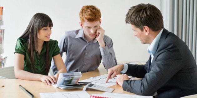 Real estate agent discussing property documents to his clients