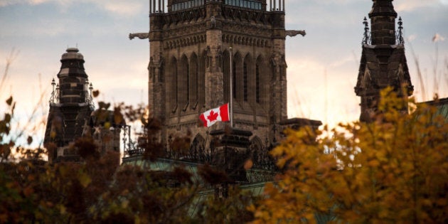 OTTAWA, ON - OCTOBER 23: A flag next to the Canadian Parliament Building is flown at half-staff one day after Cpl. Nathan Cirillo of the Canadian Army Reserves was killed while standing guard in front of the National War Memorial by a lone gunman, on October 23, 2014 in Ottawa, Canada. After killing Cirillo the gunman stormed the main parliament building, terrorizing the public and politicians, before he was shot dead. (Photo by Andrew Burton/Getty Images)