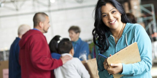 Young woman with clipboard at a donation relief center.