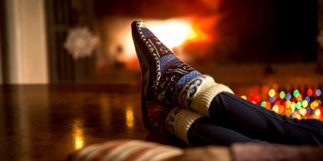 Closeup portrait of feet at woolen socks warming at fireplace in winter