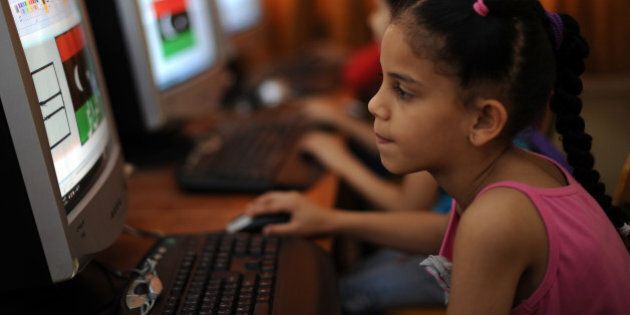 A Libyan girl uses a computer at a school organised by volunteers to keep children engaged in activities far from the fighting raging between rebels and loyalists in the eastern rebel stronghold of Benghazi on June 1, 2011. AFP PHOTO/SAEED KHAN (Photo credit should read SAEED KHAN/AFP/Getty Images)