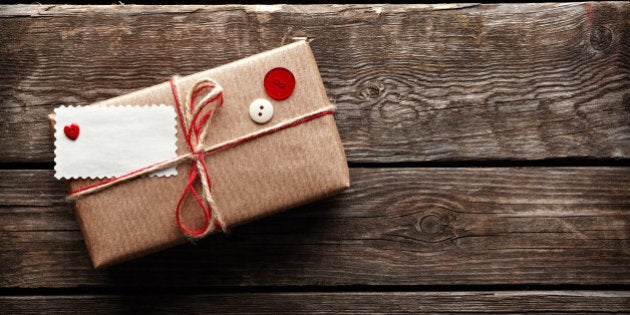 Vintage gift box (package) with blank gift tag on old wooden background.