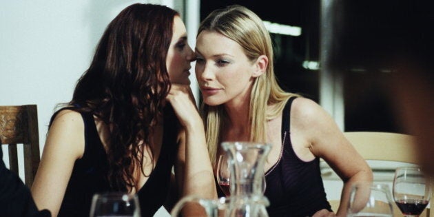 Two young women talking at dinner party