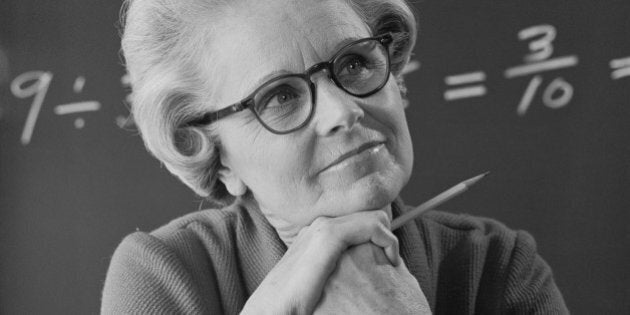 Senior female teacher with formulas in background, close-up