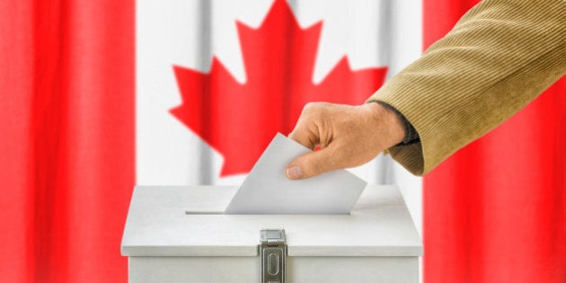 Man putting a ballot into a voting box - Canada