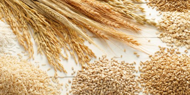 various type of cereals and grains against white wood background