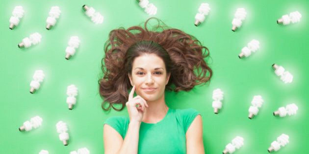 Girl laying on Green background with CF light bulbs around her
