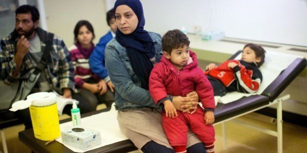 Members of a Syrian refugee family from Damascus wait to get vaccinations at the State Office of Health and Social Affairs (LAGeSo) in Berlin on October 1, 2015. A record 270,000 to 280,000 refugees arrived in Germany in September, more than the total for 2014. The sudden surge this year has left local authorities scrambling to register as well as provide lodgings, food and basic care for the new arrivals. AFP PHOTO / DPA / KAY NIETFELD +++ GERMANY OUT +++ (Photo credit should read KAY NIETFELD/AFP/Getty Images)