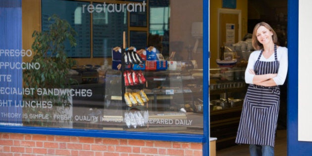 Woman standing in doorway of restaurant smiling