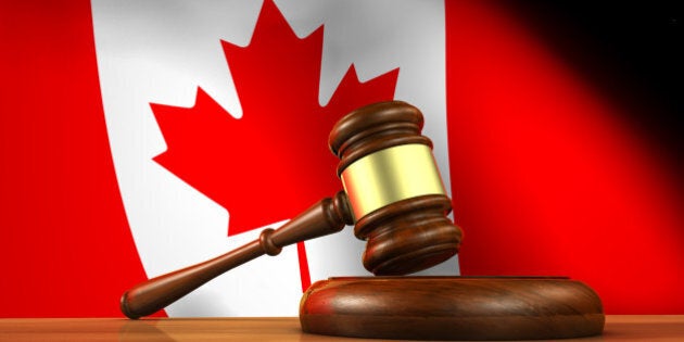 Law and justice of Canada concept with a 3d rendering of a gavel on a wooden desktop and the Canadian flag on background.