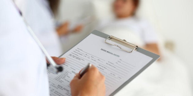 Female medicine doctor filling in patient medical history list during ward round. Medical care or insurance concept. Physician ready to examine patient and help