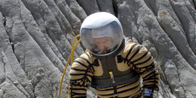 University of North Dakota Space Studies graduate studen Fabio Sau tests out a experimental planetary space suit in the North Dakota Badlands near Fryburg, N.D., on Saturday, May 6, 2006. Sau is the guinea pig for an experimental Mars space suit that he and about 40 other students from five North Dakota schools developed under a $100,000 grant from NASA. The suit was formally unveiled Saturday in a craterlike area surrounded by buttes in the North Dakota Badlands, the highly eroded landscape that researchers say resembles Martian terrain. In this test the outer blue covering of the suit has been removed. (AP Photo/Will Kincaid)