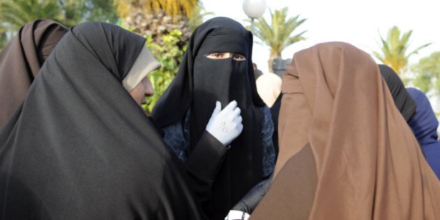 Female students, wearing a niqab, gather outside the building housing the office of the dean of the Faculty of Arts in Manuba, some 25 kms west of Tunis, on December 8, 2011. Several hundred demonstrators gathered at the university calling for women to be allowed to wear the Muslim veil in class and pass exams. A group of Salafists disrupted classes on November 28 at the university, demanding to stop mixed-sex classes and for female students to wear full face veils. AFP PHOTO / FETHI BELAID (Photo credit should read FETHI BELAID/AFP/Getty Images)