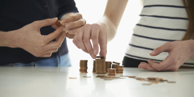 Midsection of mother and daughter stacking coins at table