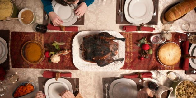 Family observing burnt turkey on dining room table