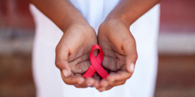 Child's hands holding an HIV awareness ribbon, Cape Town, South Africa