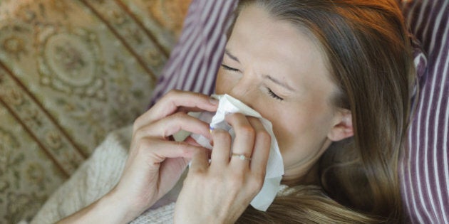 Cold flu illness of woman - tissue blowing runny nose at home