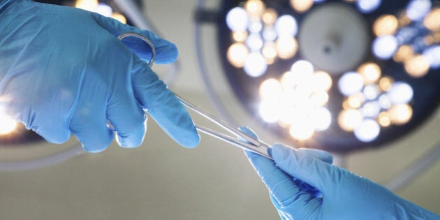 Close-up of gloved hands passing the surgical scissors, operating room, hospital