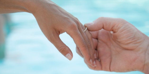 male hand tenderly touching bride's wedding band