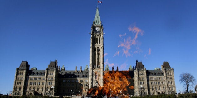 The Centennial Flame stands in front of the Centre Block and Peace Tower of Parliament on Parliament Hill in Ottawa, Ontario, Canada, on Tuesday, Oct. 29, 2013. Stephen Poloz, governor of the Bank of Canada, said the central bank is modifying the format of its quarterly monetary policy reports to explicitly capture uncertainty in its outlook. Photographer: Patrick Doyle/Bloomberg via Getty Images