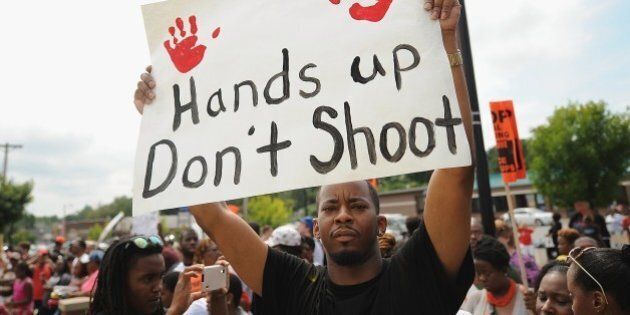 Demonstrators protest outside the Ferguson, Missouri, police department during the National March on Ferguson, August 30, 2014. The protesters demanded justice for Michael Brown, 18, shot dead in a fatal encounter with police in Ferguson, Missouri, a St Louis suburb, on August 9. AFP PHOTO/Michael B. Thomas (Photo credit should read Michael B. Thomas/AFP/Getty Images)