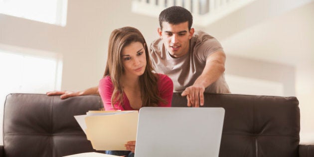 Couple reading papers at laptop together