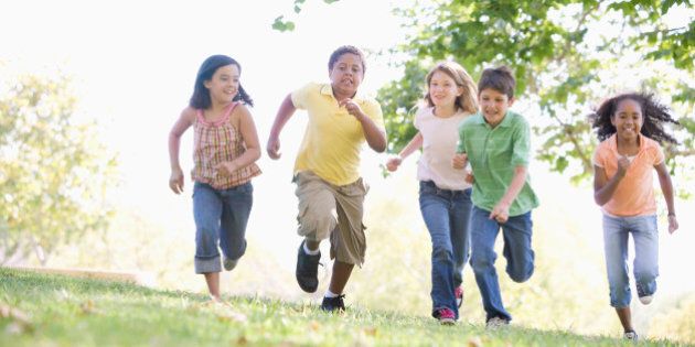 Five young friends running outdoors smiling