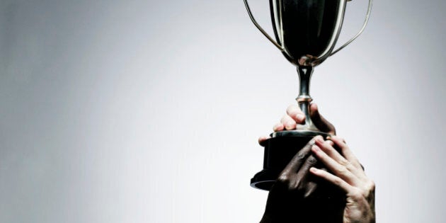 Two men holding trophy, close-up