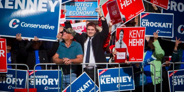 Attendees holds signs in support of different candidates ahead of the second leaders' debate in Calgary, Alberta, Canada, on Thursday, Sept. 17, 2015. The debate pits Prime Minister Stephen Harper and his Conservative Party's program of tax cuts and spending restraint against the Liberal Party's Justin Trudeau, who is pledging to raise taxes on the highest earners, and Thomas Mulcair of the New Democratic Party, who advocates increasing levies on corporations. Photographer: Ben Nelms/Bloomberg via Getty Images