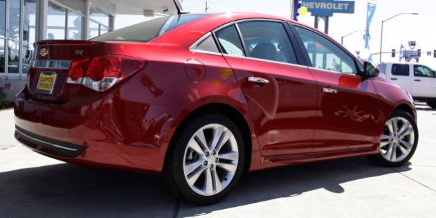 In this Aug. 30, 2011 photo a 2011 Chevrolet Cruze is displayed at a car dealership in San Jose, Calif. General Motorsâ car and truck sales rose 18 percent last month as fuel-efficient vehicles helped offset a roiling stock market and Hurricane Irene. (AP Photo/Paul Sakuma)