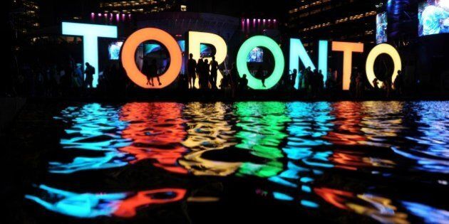 The Toronto sign is seen at the Nathan Phillips Square as people watch a concert during 2015 Pan American Games in Toronto, Canada on July 13, 2015. AFP PHOTO/HECTOR RETAMAL (Photo credit should read HECTOR RETAMAL/AFP/Getty Images)