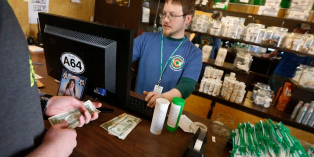 FILE - In this May 8, 2014 file photo, a customer pays cash for retail marijuana at 3D Cannabis Center, in Denver. A year after Colorado's marijuana tax for schools came in far short of its goal, the fund is setting records and has accrued more money in the first five months in 2015 than it did for all of 2014. (AP Photo/Brennan Linsley, File)