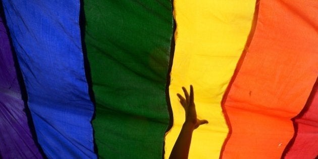 Members and supporters of the lesbian, gay, bisexual, transgender (LGBT) community walk with a rainbow flag during a rally in Kolkata on July 13, 2014. Hundreds of LGBT activists particpated in the rally to demand equal social and human rights for their community and stop social discrimination. AFP PHOTO/ Dibyangshu Sarkar (Photo credit should read DIBYANGSHU SARKAR/AFP/Getty Images)