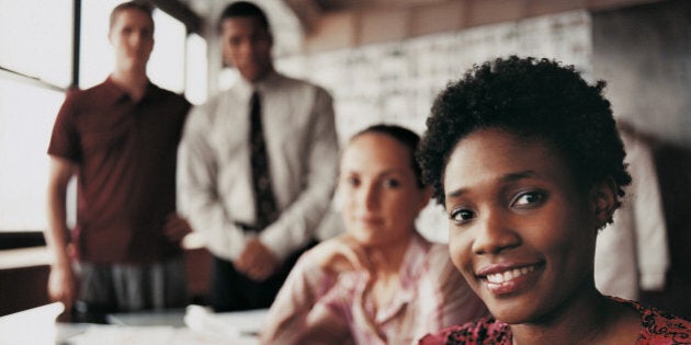 Portrait of a Fashion Designer Sitting in Front of Three of Her Colleagues at a Desk