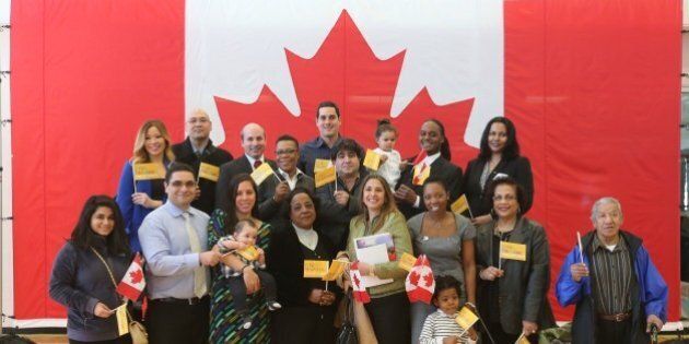 TORONTO, ON - APRIL 1: Group shot of new Canadians who originate from countries that are competing in Pan Am Games pose for pictures at the Pan Am Games celebration, 100-day countdown with citizenship ceremony for 100 new Canadians at the CIBC Pan Am/Parapan Am Athletes' Village Cooper-Koo Family YMCA building in Toronto. (Vince Talotta/Toronto Star via Getty Images)