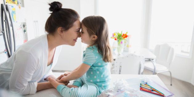 Affectionate mother and daughter rubbing noses in pajamas