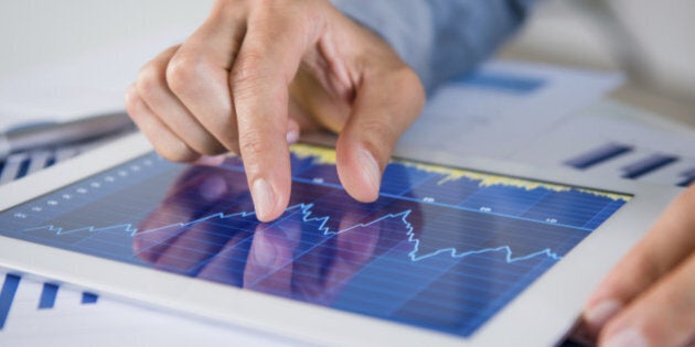 Close Up Of Businessman's Hand Analysing Graph On Digital Tablet