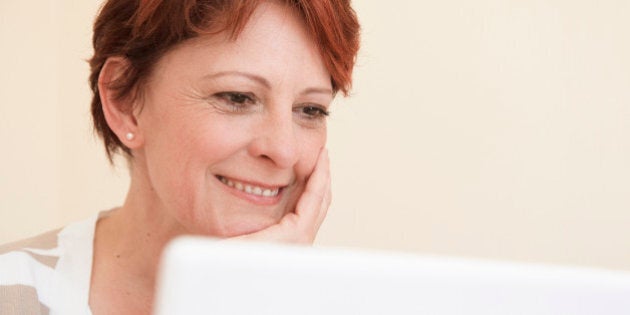 Smiling woman using laptop