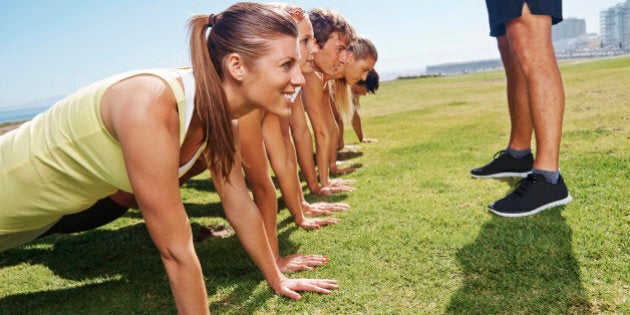 A group of young people doing pushups, during a boot camp