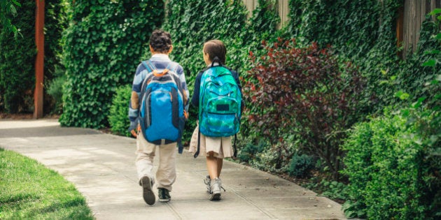 Mixed race brother and sister walking on sidewalk