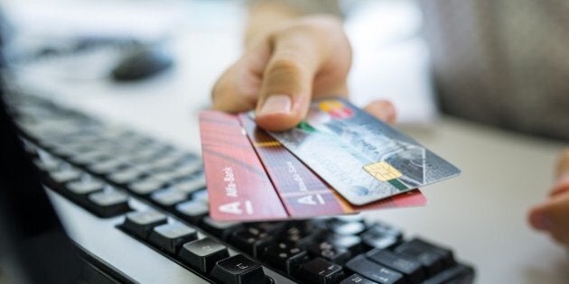 VORONEZH, RUSSIA - JULY 25: Man holding a Russian credit cards of Sberbank and Alfa Bank in his hand on July 25, 2015 in Voronezh, Russia. (Photo by Oleg Kharseev/Kommersant Photo via Getty Images)